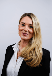 Porträtfoto einer Frau mit langen blonden Haaren und weißer Bluse.